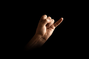 Male hand making pinky swear sign over dark background. The concept of friendship, quarrel, human...