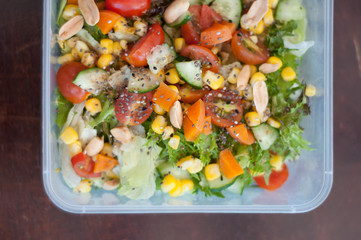 Close up of fresh and healthy salad made with fruits and vegetables in a container.