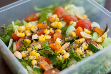 Close up of fresh and healthy salad made with fruits and vegetables in a container.