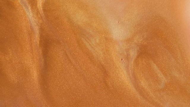 Colorful golden sand organically moves in colorful liquid