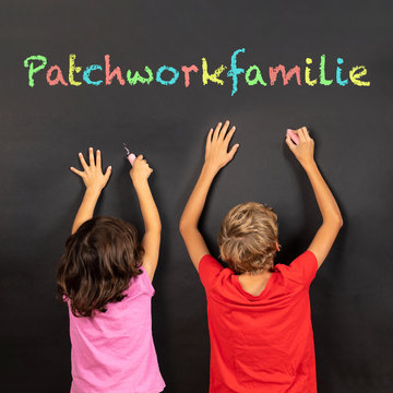 girl and boy writing on a blackboard with german text patchworkfamilie, in english patchwork family