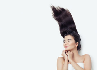 Happy woman brunette with blowing up curly hair on white. Emotion, expressive facial expression