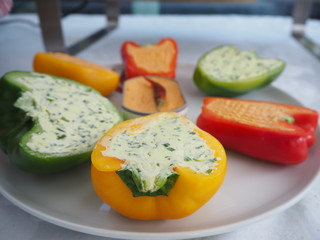 Party food filled capsicum in different colours decorated on a white plate.
