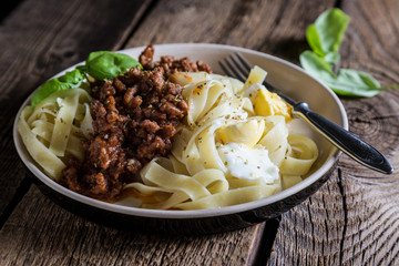 bolognese pasta on wooden table