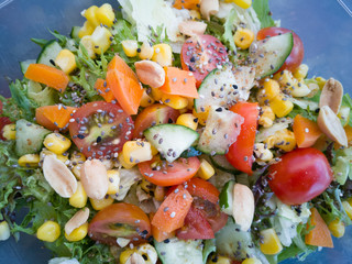 Close up of fresh and healthy salad made with fruits and vegetables in a container.