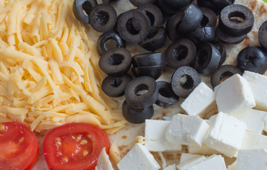 Chicken, tomatoes, cheese, olives - the ingredients for pizza. Food photography concept