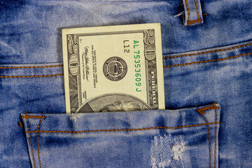 Twenty dollars bill in the pocket of blue jeans