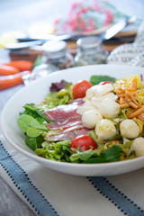 Salad with fusilli pasta accompanied tomatoes, mozzarella, smoked ham and italian cheese
