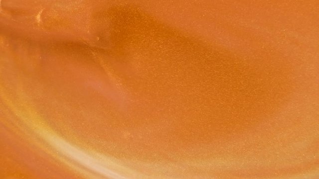 Colorful golden sand organically moves in colorful liquid