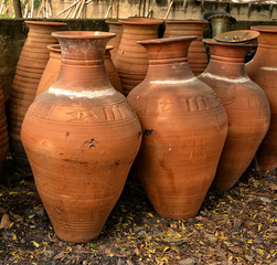 Fototapeta na wymiar Clay pots stacked for sale on country roads. Pottery making place. Local craft market. Beautiful handmade terracotta pots. Craftsmanship.