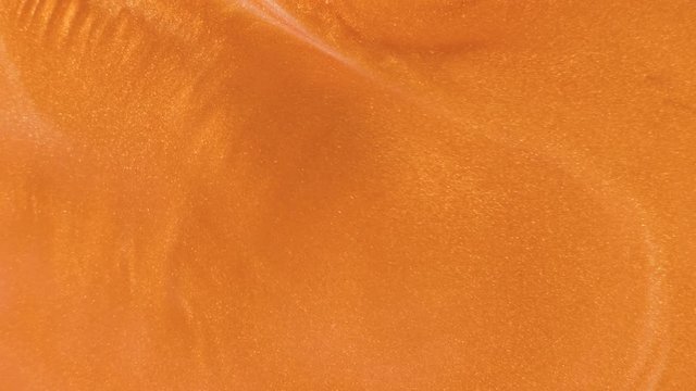 Colorful golden sand organically moves in colorful liquid