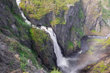 Side view of the foot of the Voringfossen with the valley in the mist of the waterfall.