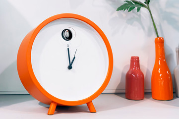 Orange cuckoo alarm clock in modern interior.
