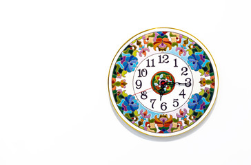 Ceramic clock with bright patterns on a white background.