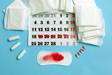 Menstruation cycle concept. Menstruation calendar with sanitary pads, contraceptive pills, tampons