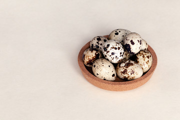 Closeup Easter small fresh textural quail eggs in round wooden bowl with textile isolated on white background. Concept traditional treat Orthodox Christian spring Church holiday. Free space, copyspace