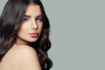 Fototapeta premium Young female face. Healthy skin, long curly hair