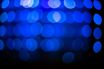 Abstract glitter defocused blue lights bokeh texture on black background