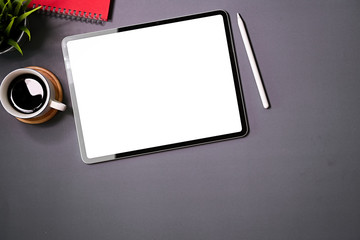 Blank screen digital touchscreen tablet on gray office desk top view and copy space