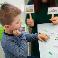 Young boy in speech therapy office. Preschooler exercising correct pronunciation with speech therapist. Child Occupational Therapy Session. - obrazy, fototapety, plakaty