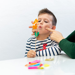 Young boy in speech therapy office. Preschooler exercising correct pronunciation with speech therapist. - obrazy, fototapety, plakaty