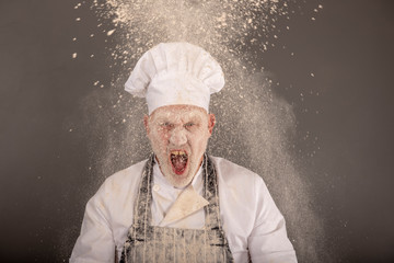 Angry chef shouting in a flour cloud 