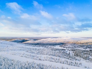 Fototapeta na wymiar Aerial view of snow covered winter forest and road. Beautiful rural landscape in Finland