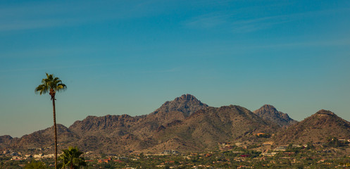 Fototapeta na wymiar Neighborhoods at the base of tall mountains are rapidly growing in the Phoenix, Arizona area where population is steadily growing. Housing in these mountain base developments are usually more expensiv
