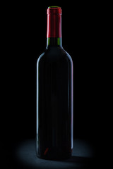 bottle of red wine on black background.