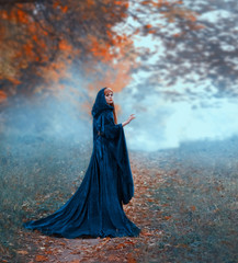 female magician flees in the autumn orange forest, wearing a blue velvet cloak with a hood and wide...