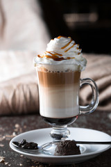 Tasty hot coffee with cream and caramel sauce