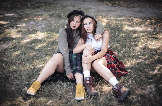 Two girls spend time together outdoors. The concept of difficult teenagers, bad students.