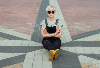 woman in sunglasses sitting on the town square