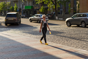 woman crosses the street at a pedestrian crossing