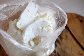 Cottage cheese is classical dairy product. It is made of milk of mammals. Cottage cheese is in a plastic bag.