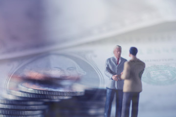 Double exposure row of coins of Two Business man and graph,saving,investment and finance concepts. Miniature people Stand behind of a red pen,soft focus and blurred style.