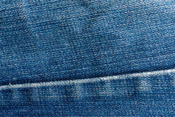 Old blue jeans. Denim Texture. Seam passes through the fabric.