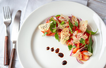 Vegetarian Italian salad of cherry tomatoes with Basil and croutons on a white plate, ideas for a healthy diet