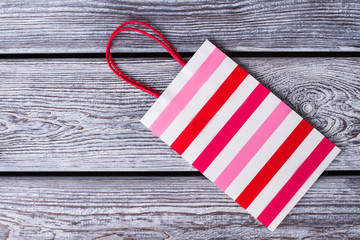 New striped paper gift bag. Laminated shopping paper bag with colorful stripes design on gray...