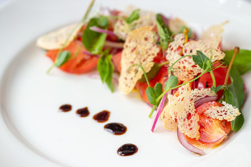 Vegetarian Italian salad of cherry tomatoes with Basil and croutons on a white plate, ideas for a healthy diet