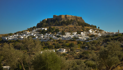 Fototapeta na wymiar LINDOS,RHODES/GREECE OCTOBER 29 2018 : The Acropolis and the village of Lindos photo taken from Kleovoulos Tomb hill