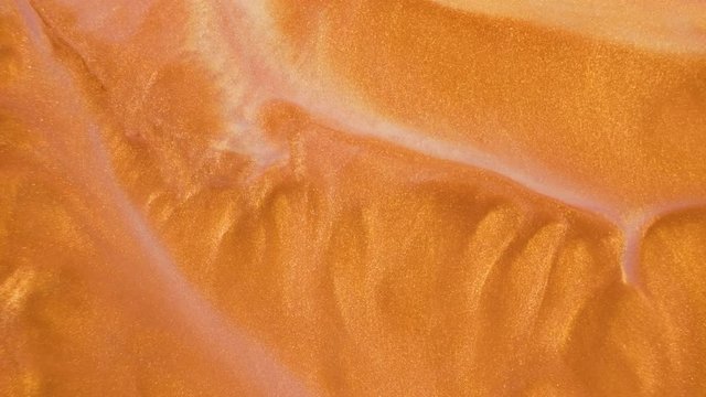 Colorful golden sand organically moves in colorful liquid