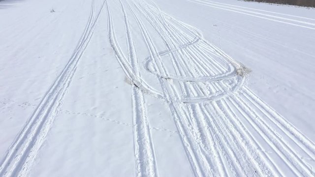 Marks in the snow from different vehicles 4K drone video