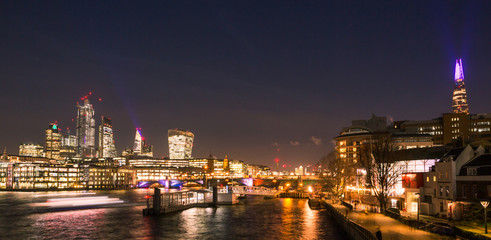 Obraz premium London Skyline at Night with Thames River, Bridges, City Buildings and Riverboats Crossing