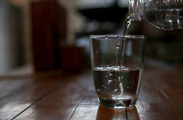 People are pouring water into the glass.