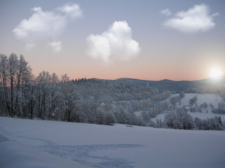 Background photo of low clouds in a mountain valley, vibrant blue and orange sky. Sunrise or sunset view of mountains and peaks peaking through clouds.