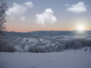 Background photo of low clouds in a mountain valley, vibrant blue and orange sky. Sunrise or sunset view of mountains and peaks peaking through clouds.