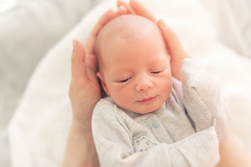 Baby in the hands of mom close up.