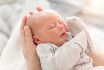 Baby in the hands of mom close up.
