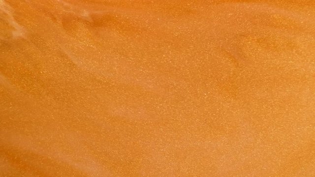 Colorful golden sand organically moves in colorful liquid